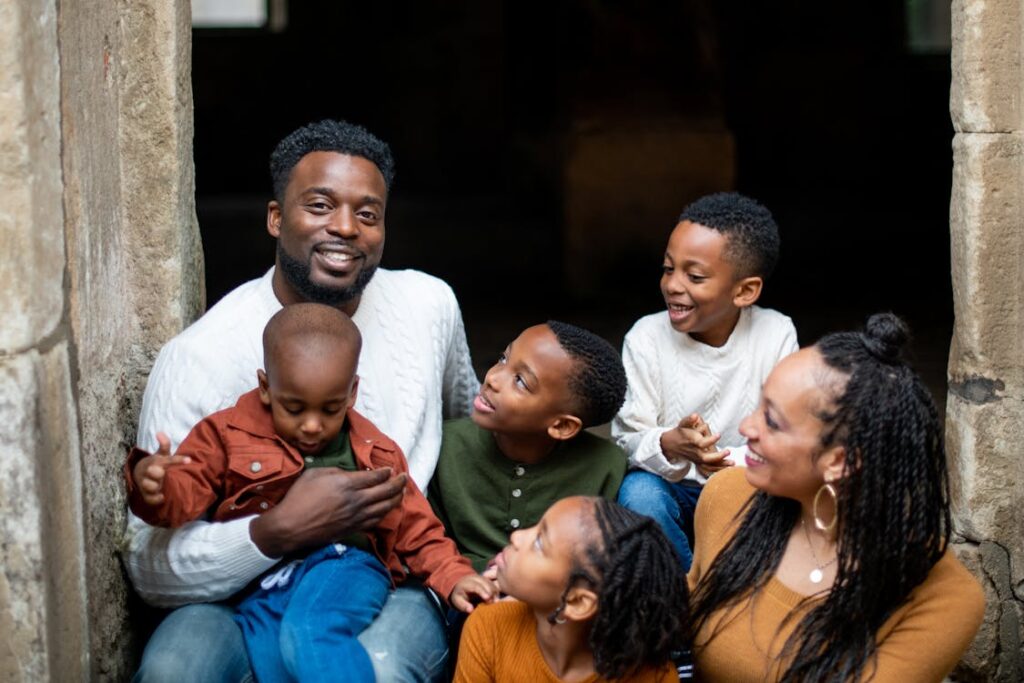 Smiling Black family sitting together, representing community strength and resilience.