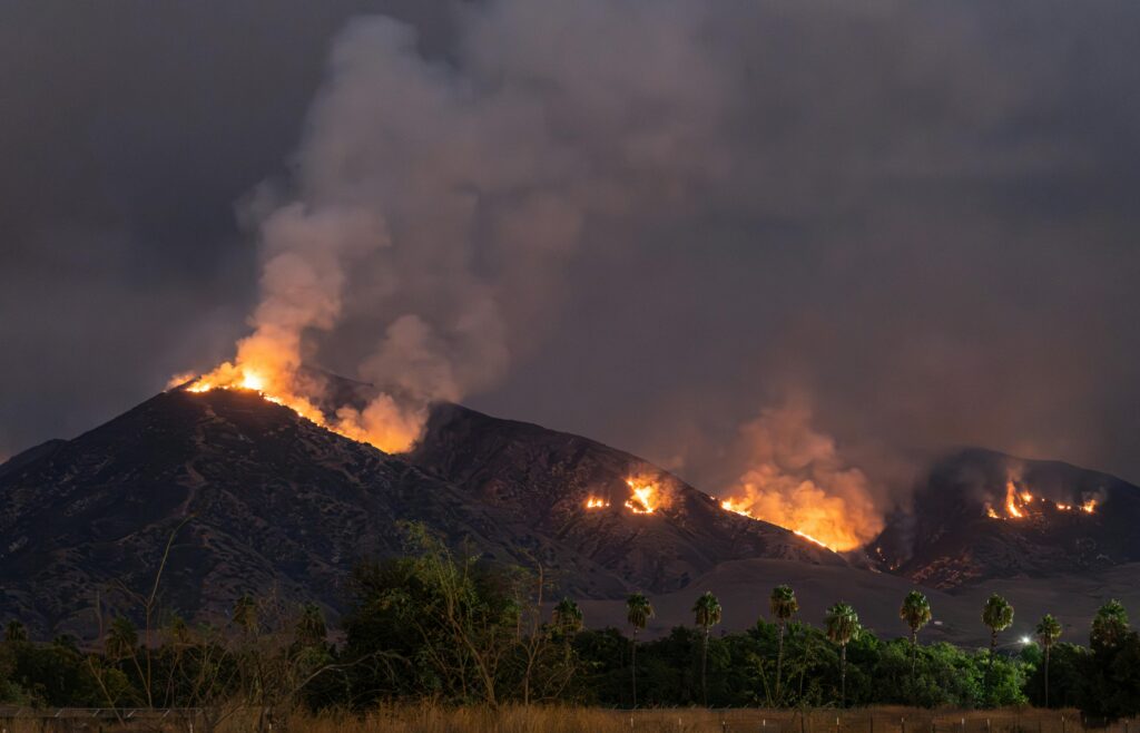 Wildfire glowing over mountain ridges.